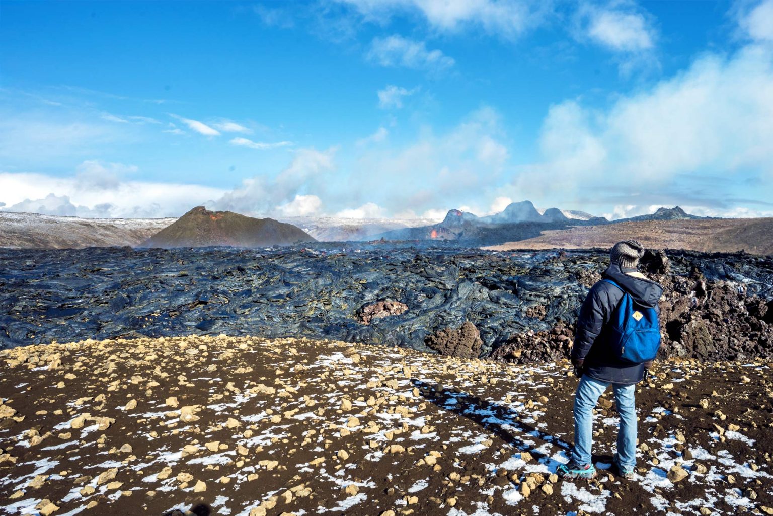 Man standing next to the recent volcano lava fields on Reykjanes Iceland